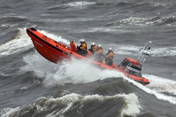 Modern Blackpool, England lifeboat surging through wild Irish sea waves